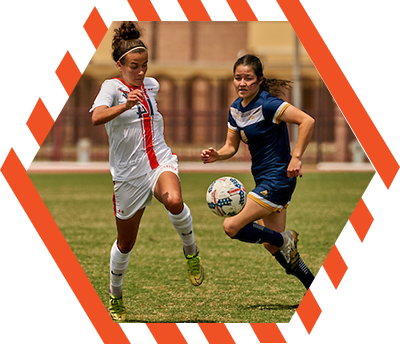 two female soccer players competing for the ball